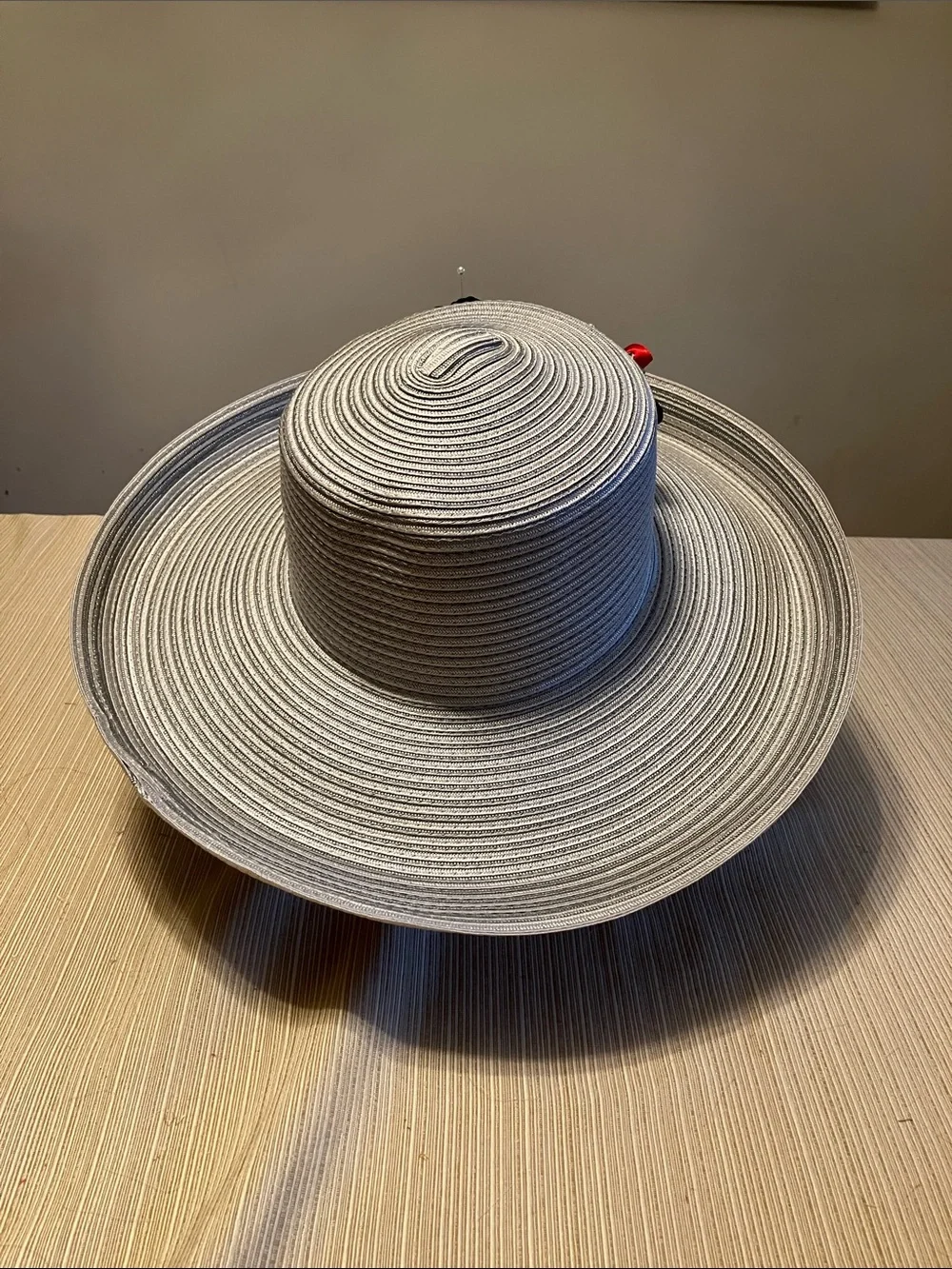 Wide Brim Straw Hat with Black Decorative Knot and Red Floral Accent